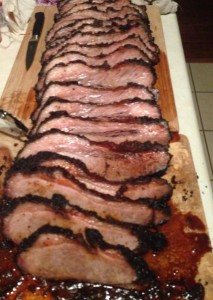 smoked sliced brisket on wooden carving board